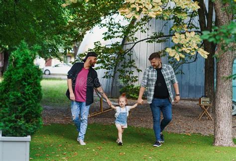 Pareja Gay Caminando Con Un Niño Adoptado En El Parque Imagen de archivo Imagen de exterior