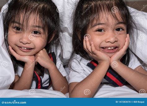 Irm Feliz Dos G Meos Das Meninas Na Cama Sob A Cobertura Que Tem O