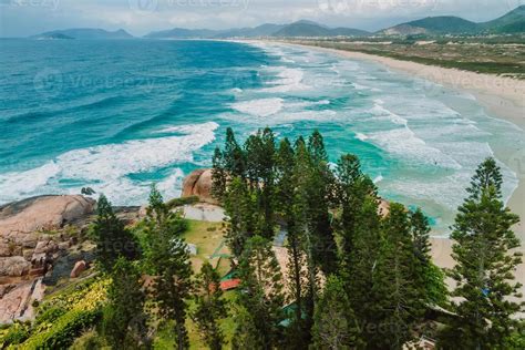 Joaquina Beach With Evergreen Trees And Atlantic Ocean With Waves In