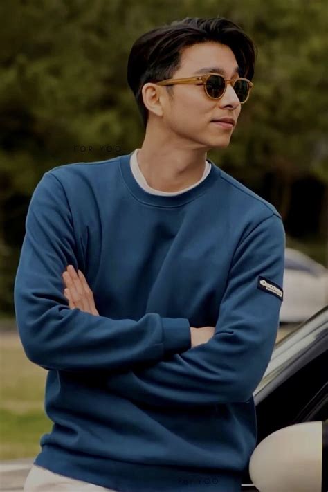 A Man With His Arms Crossed Sitting On The Hood Of A Car