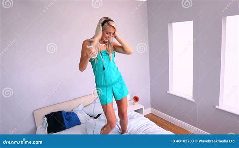 Attractive Blonde Dancing On Bed And Listening To Music Stock Video