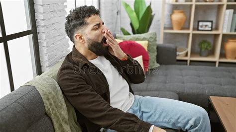 At Home An Exhausted Young Man Yawning Out Of Sheer Boredom