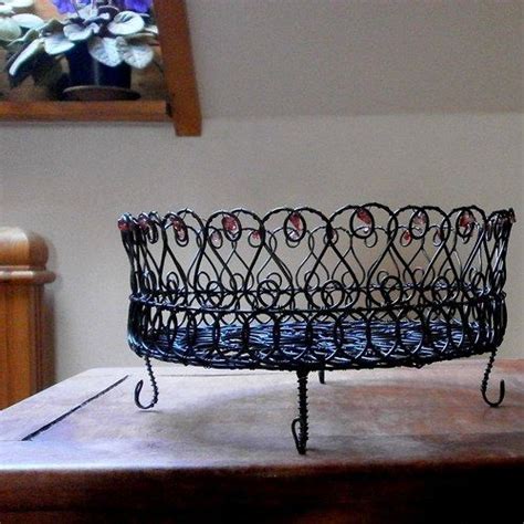 A Metal Basket Sitting On Top Of A Wooden Table Next To A Mirror With