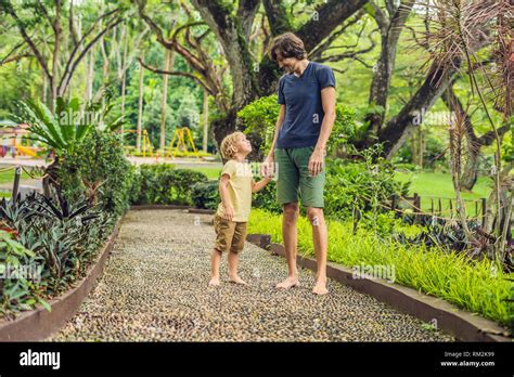 Padre E Hijo Caminando Sobre Un Pavimento De Guijarros Con Textura