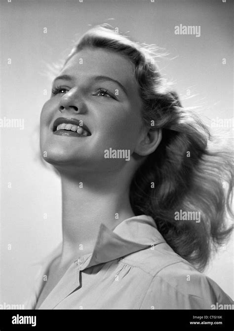 SMILING PORTRAIT jeune femme blonde avec la tête inclinée en arrière du vent qui souffle