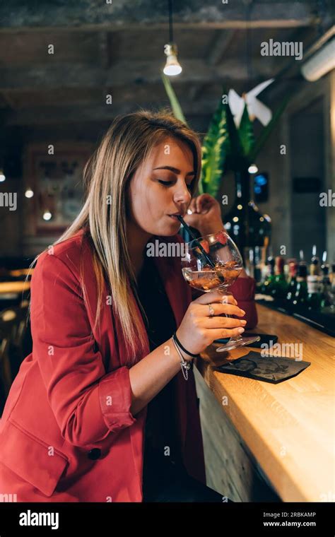 Blonde Girl Drinking A Cocktail In A Bar Stock Photo Alamy