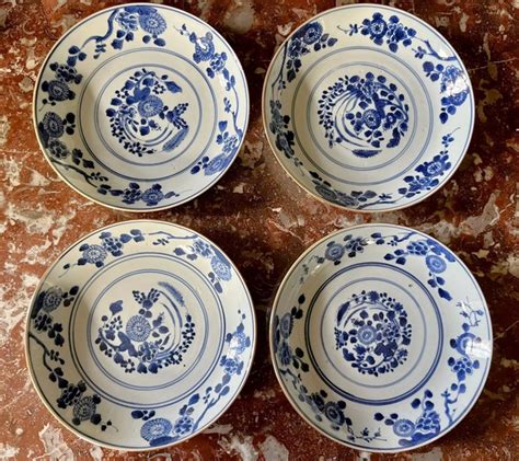 CHINE Quatre assiettes creuses en porcelaine à décor blanc bleu