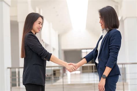 Dos Exitosas Mujeres De Negocios Se Dan La Mano Con Un Socio Para