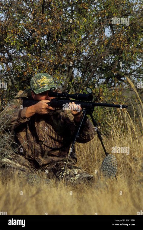 A South Texas Deer Hunter Looking Through His Scope And Aiming A Rifle