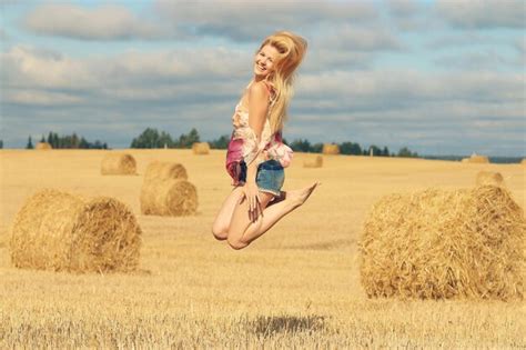Premium Photo Beautiful Blonde Jumps In Sloping Field Sun Happiness