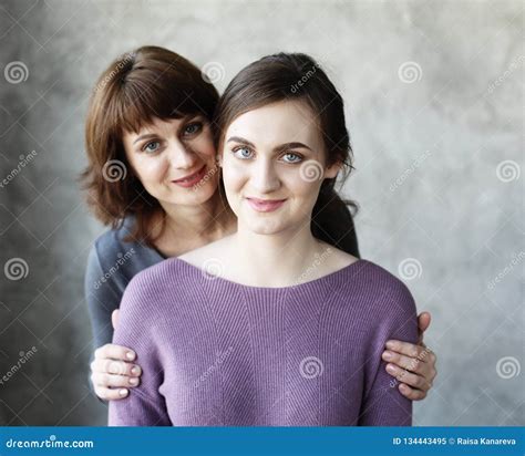 Happy Senior Mother Embracing Adult Daughter Laughing Together Stock