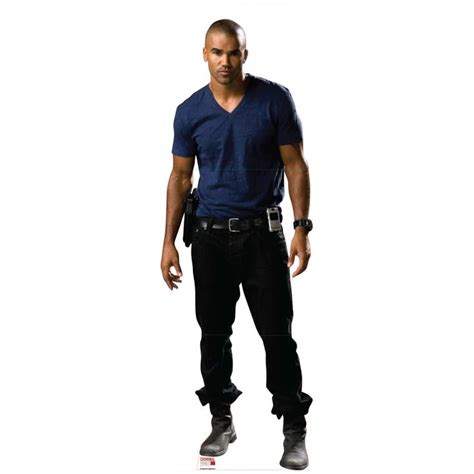 A Man Standing In Front Of A White Background Wearing Black Pants And A