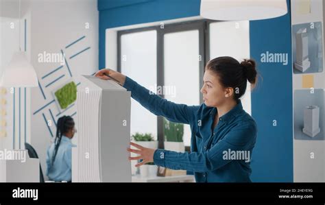 Close Up Of Woman Designing Blueprints Plans After Looking At Building