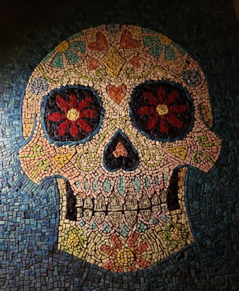 A Mosaic Skull With Red Flowers On It