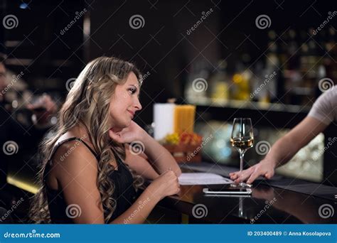 Cute Blonde Girl Ordered Wine From The Bartender In A Nightclub Stock