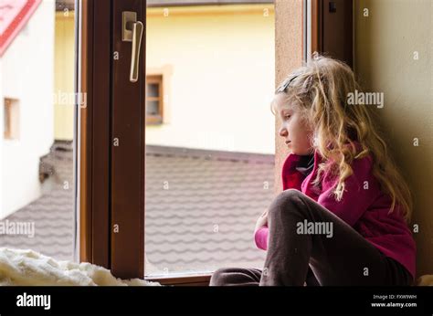 lonely girl sitting by the window Stock Photo - Alamy