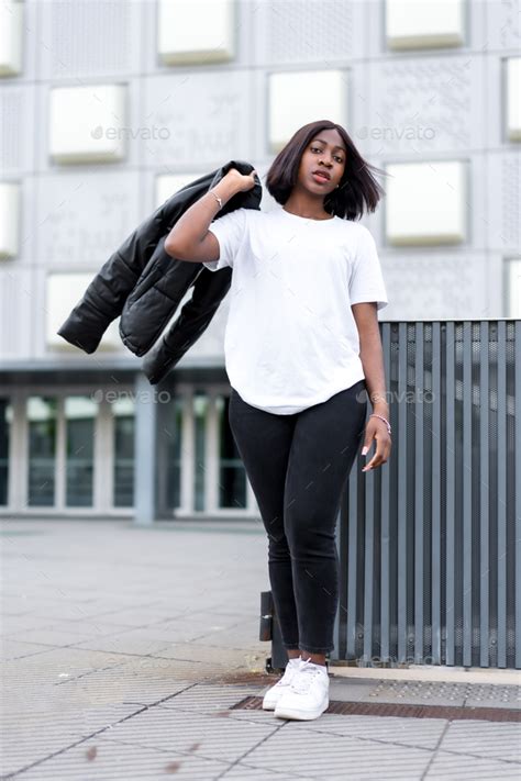 Sleek and chic: A young black woman poses in a fashionable white t ...