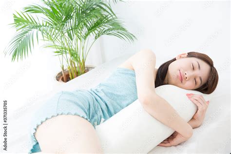 Zdjęcie Stock 抱き枕を抱いて眠る女性 Adobe Stock