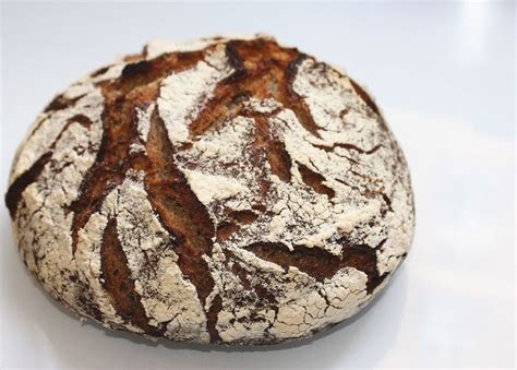 A Round Loaf Of Bread Sitting On Top Of A White Table