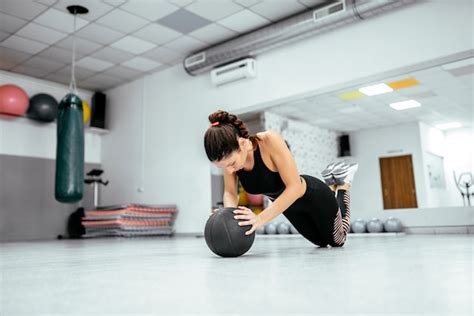 El Hacer Fuerte Hermoso De La Mujer Empuja Hacia Arriba En Bola En El