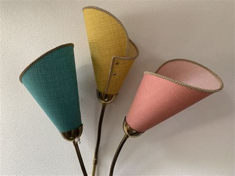 Three Different Colored Lamps Hanging On The Wall