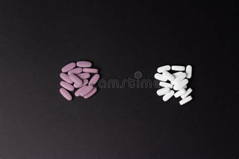 Two Piles Of Pills Lie On A Black Background White And Purple Choice