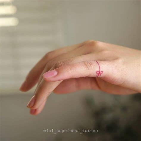 Fine Line Ribbon Ring Tattoo On The Finger