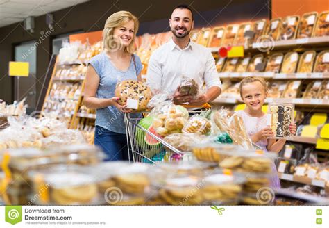 Retrato De La Familia Que Elige El Pan Y Los Dulces En La Sección De La