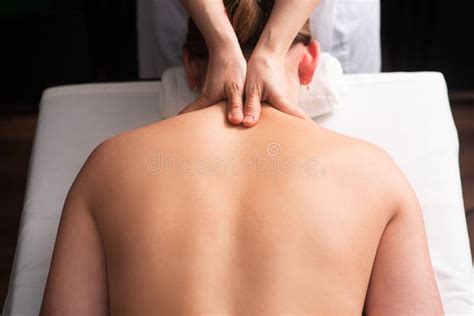 Masseur Massaging Back And Shoulder Blades Of Young Woman On Massage