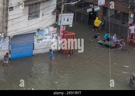 Rickshaw Owners Struggle To Wade Through A Waterlogged Street Following