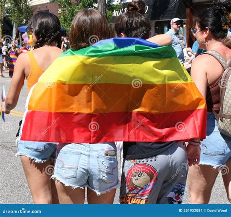Pareja Envuelta En Una Bandera Arco Iris Durante Un Desfile Del Orgullo Gay Imagen De Archivo