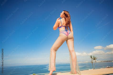 Redhead Woman In Bikini Wearing Beach Fashion Pants Modeling And Posing For The Camera Stock