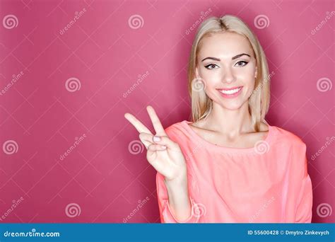 Femme Aux Cheveux Blonds De Sourire Se Dirigeant Avec Des Doigts Photo