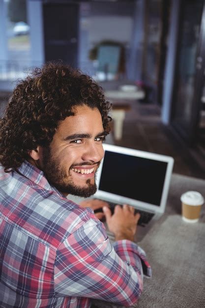 Premium Photo | Man smiling while using laptop