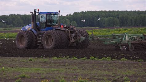 Blue New Holland Tractor With Double Wheels Pulling Disc Harrow With