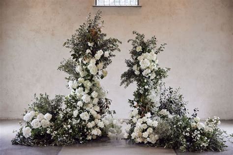 Two Floral Arrangements Are Arranged On The Floor In Front Of An Open