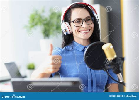 Woman Radio Host In Headphones With Microphone Holds Thumbs Up Stock