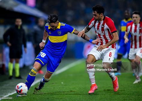 Luis Vazquez of Boca Juniors fights for the ball with Emmanuel Mas of ...