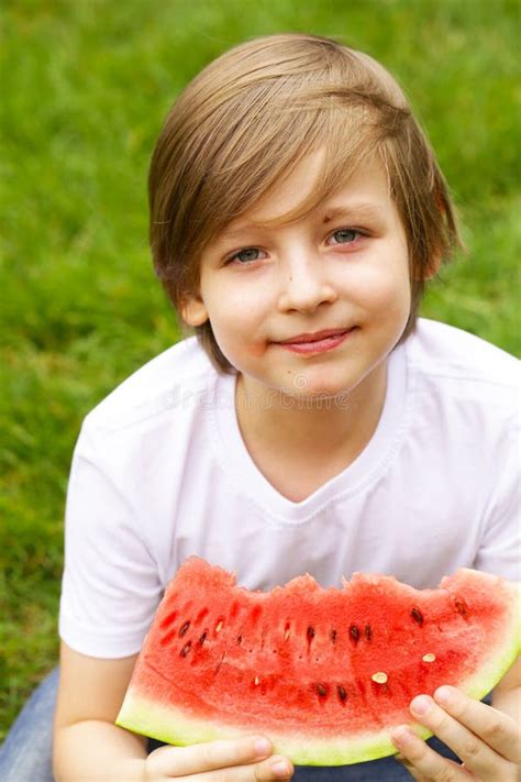 De Leuke Blonde Jongen Eet Een Rijpe Rode Watermeloen Stock Afbeelding Image Of Watermeloen