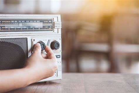 Premium Photo Woman Hand Adjusting The Sound Volume On Retro Radio