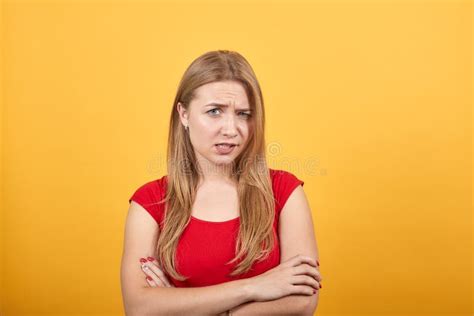 Une Jeune Fille Blonde En T shirt Rouge Sur Fond Orange Isolé Montre Des émotions Photo stock