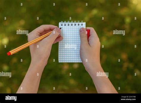 Kids Hand Holding Pen And Spiral Notepad As Mockup For Design Outdoor