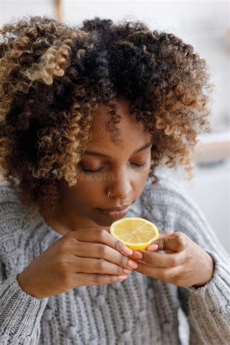 African American Woman with a Cold Stuffy Nose Sniffs Lemon. with Sore ...