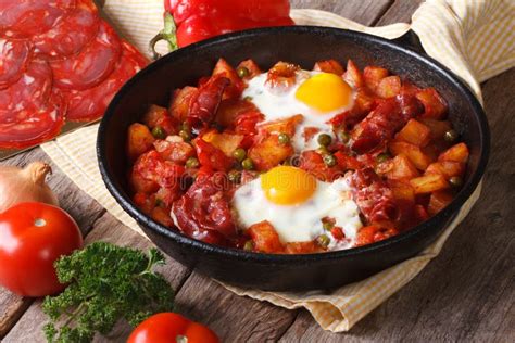 Huevos Fritos Con El Chorizo En Receta Flamenca En La Cacerola Imagen