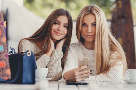 Deux Filles Observent Des Photos Sur Le Smartphone Image Stock Image