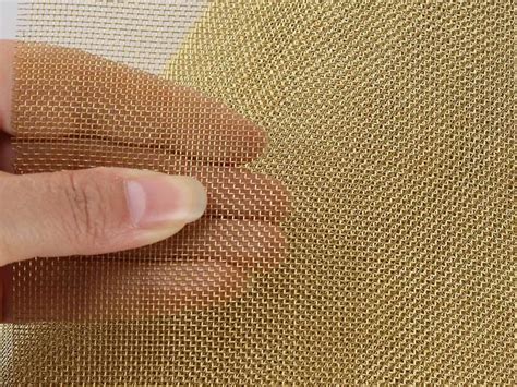 A Brass Mesh Screen Roll And A Section Hold By A Hand Window Screens