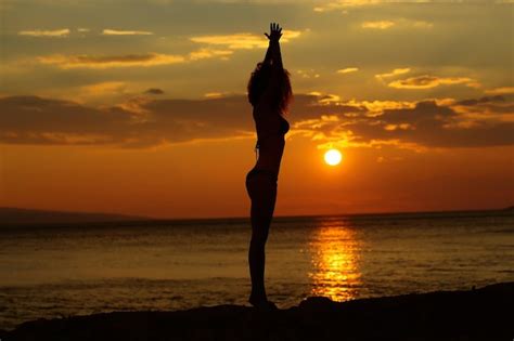 Premium Photo | Woman silhouette in sunset beach