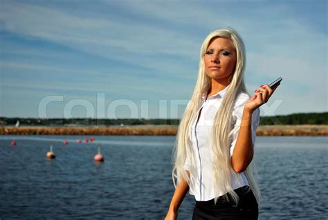 Blonde Mädchen stand mit Handy am Strand Stock Bild Colourbox