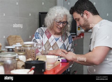 Mature Mother And Adult Son Preparing Some Sweets In The Kitchen Together Stock Photo Alamy