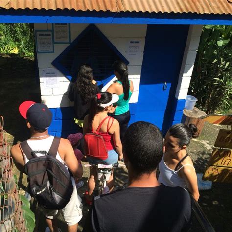 Several People Standing In Front Of A Blue And White Building